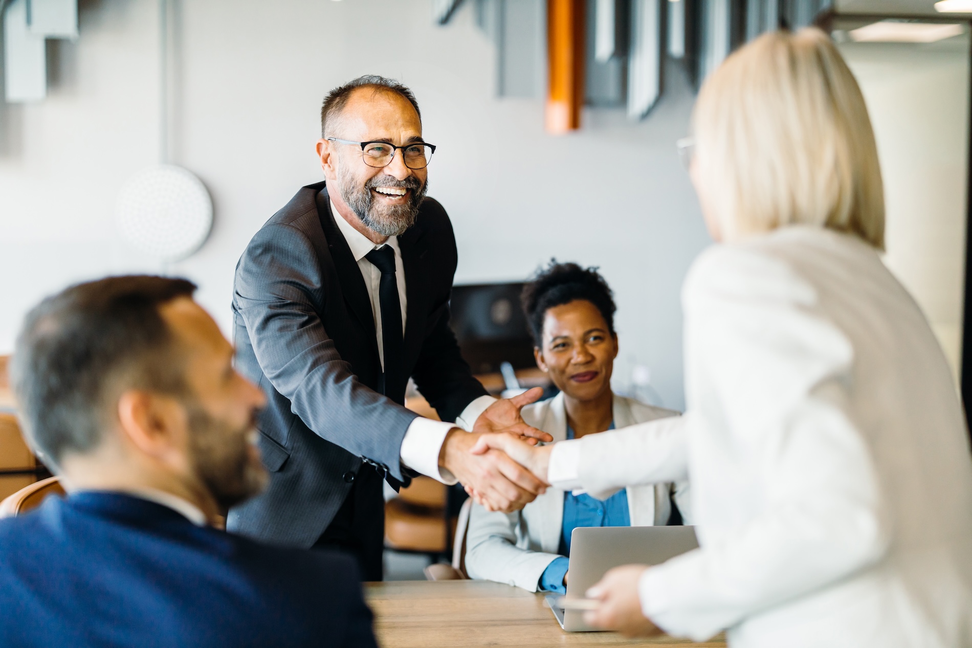 Business Broker Vancouver BC greeting each other with a handshake during a meeting—representing trust, partnership, and successful negotiations to buy or sell a business.